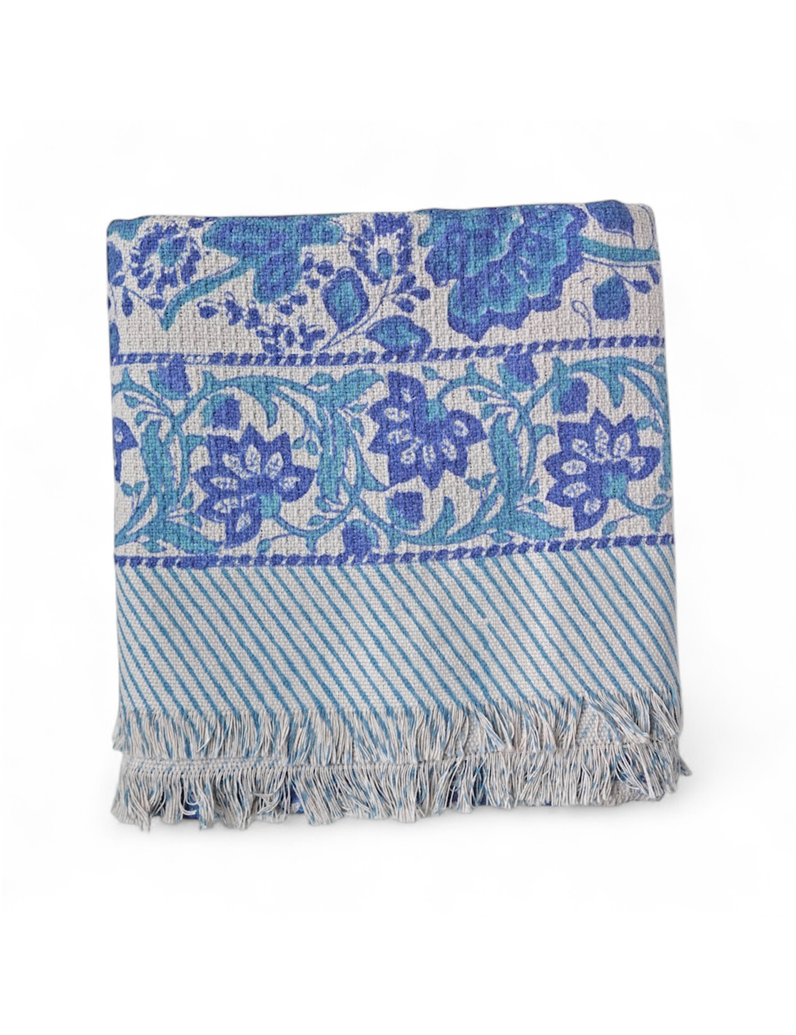 Blue and white patterned bath towel with fringes on a white background