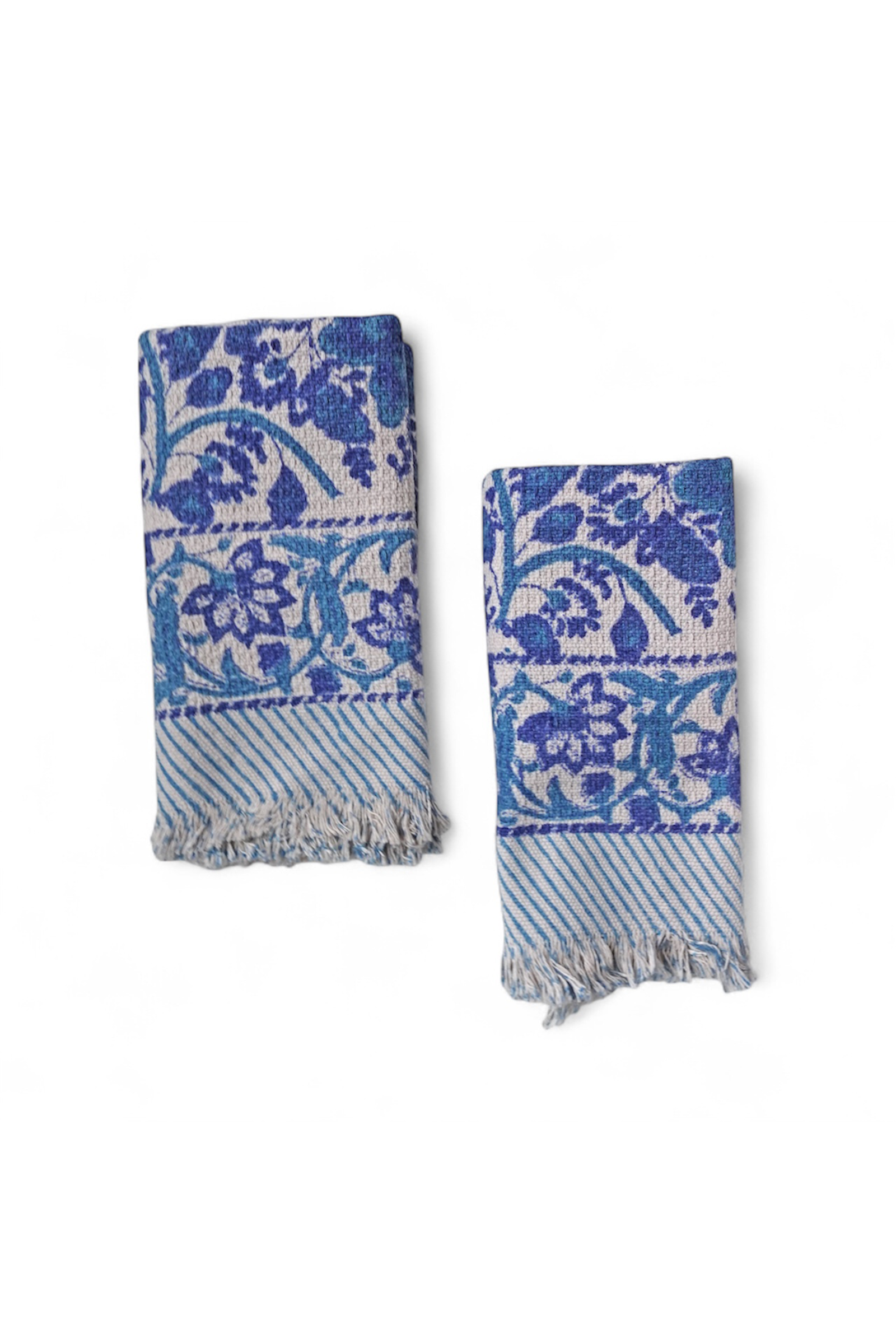 Two blue floral patterned towels on a white background
