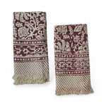 Two patterned hand towels with red floral pattern and fringes on a white background