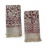 Two patterned hand towels with red floral pattern and fringes on a white background