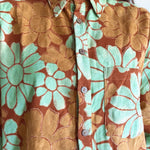 Close-up of a floral shirt with orange and green flowers.