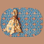 Block printed floral cotton oval placemat, front design, styled with Marigold napkin on top, tied into a napkin ring. 
