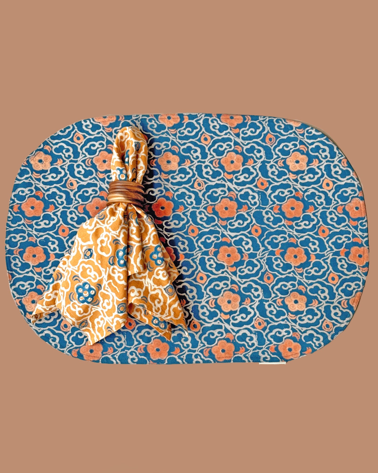 Block printed floral cotton oval placemat, front design, styled with Marigold napkin on top, tied into a napkin ring. 
