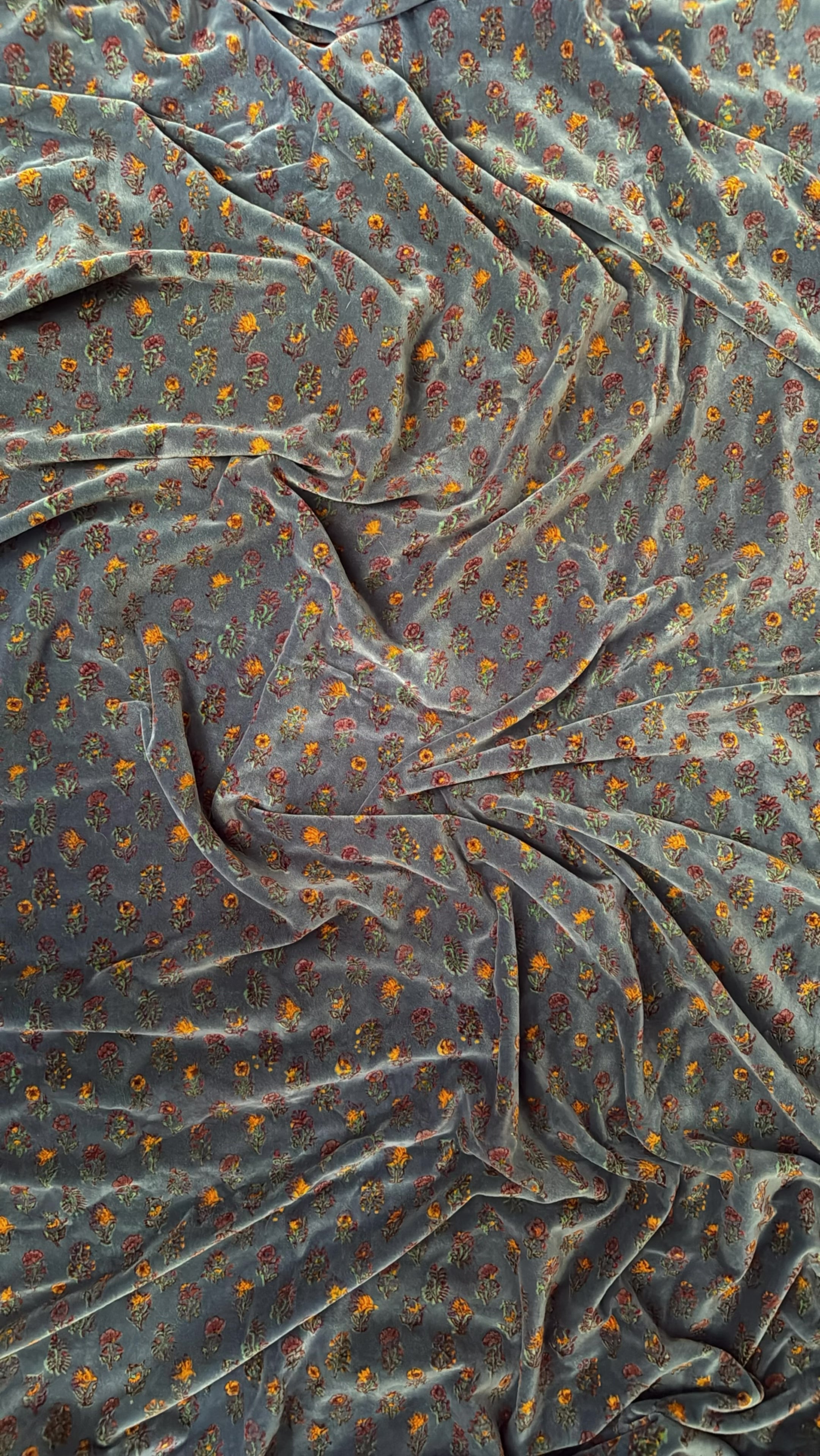 Gif showing floral printed pillow coming into shot, rotating and moving out of shot. Blanket in background flip flops between two different floral prints. 