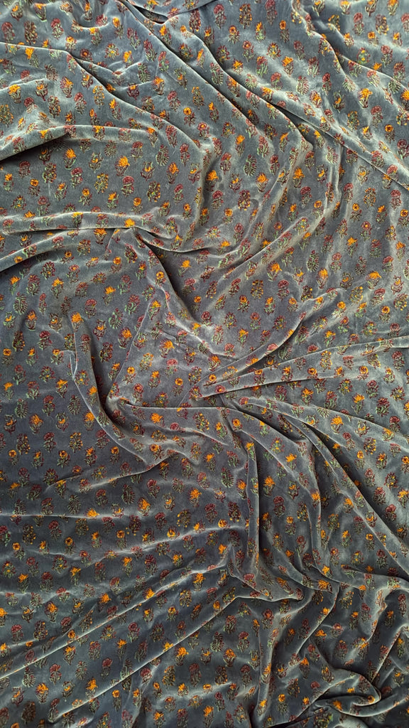 Gif showing floral printed pillow coming into shot, rotating and moving out of shot. Blanket in background flip flops between two different floral prints. 