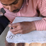 Artist hand carving the Flora print into a wooden block