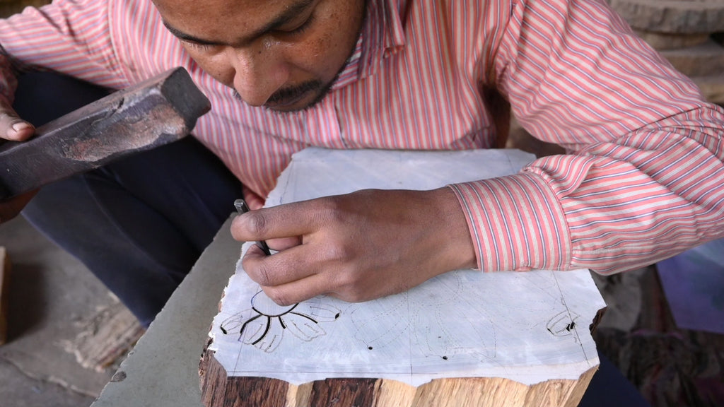 Artist hand carving the Flora print into a wooden block