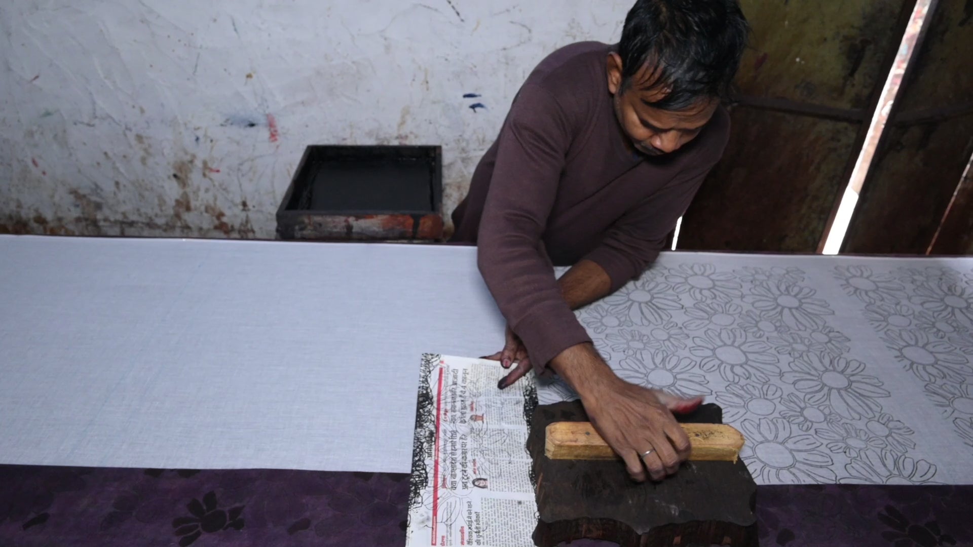 Artist block printing the outline of the Flora bandana print