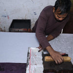 Artist block printing the outline of the Flora bandana print