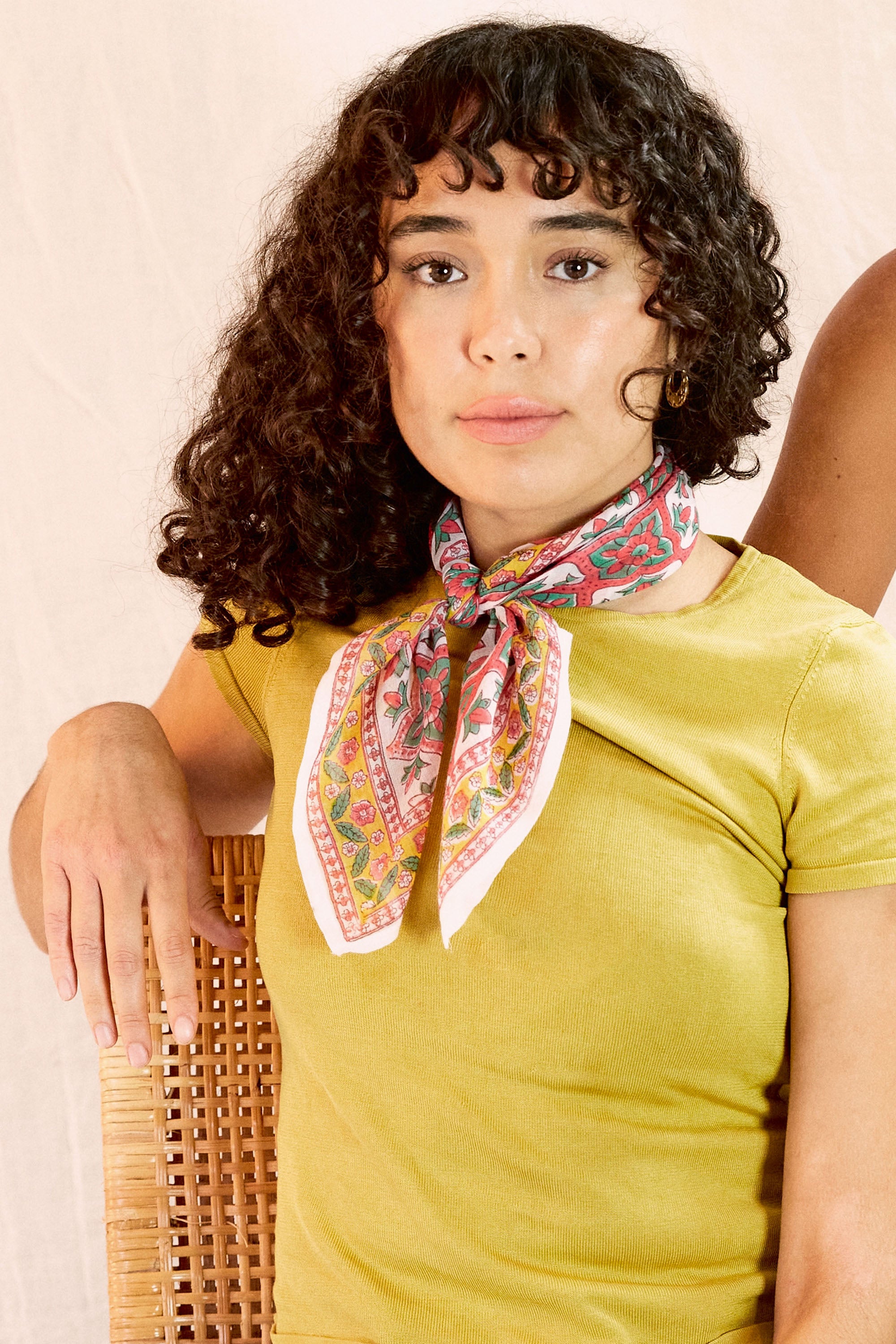 Model wearing the Zoe bandana tied around her neck, against a creamish background
