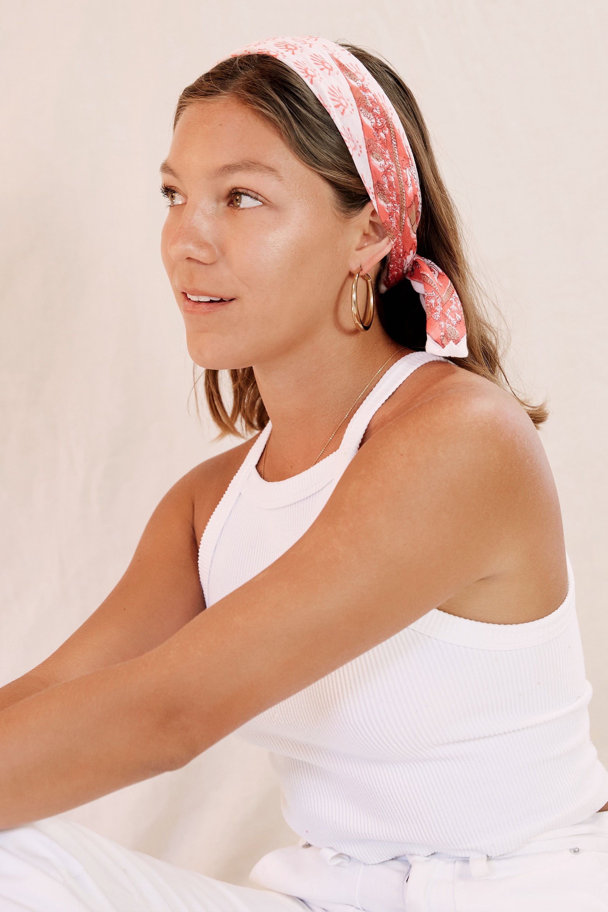 Model wearing the Elsa bandana in her hair as a headband, against a creamish background