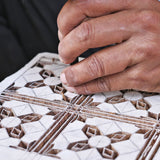 Hand carving the Alia print onto a wooden block