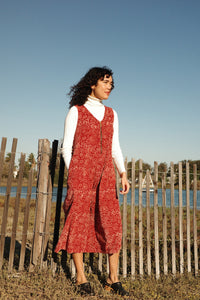 Model wearing the Estella Jumpsuit outside near water over a white long sleeve