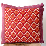 Pitaya block print pillow on a stool against white