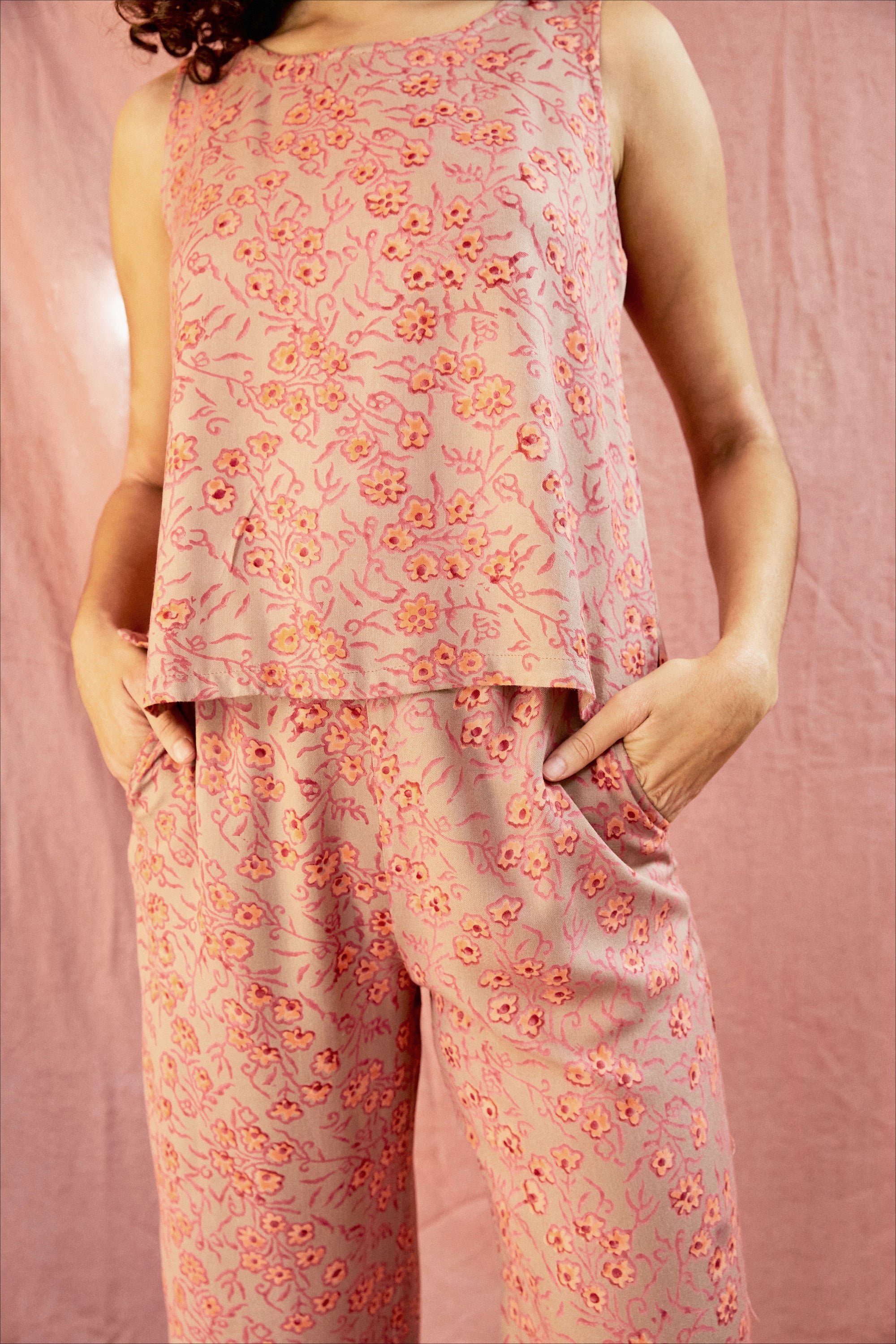 Model wearing the Birkin set, against a blush pink background, close up of pant pockets