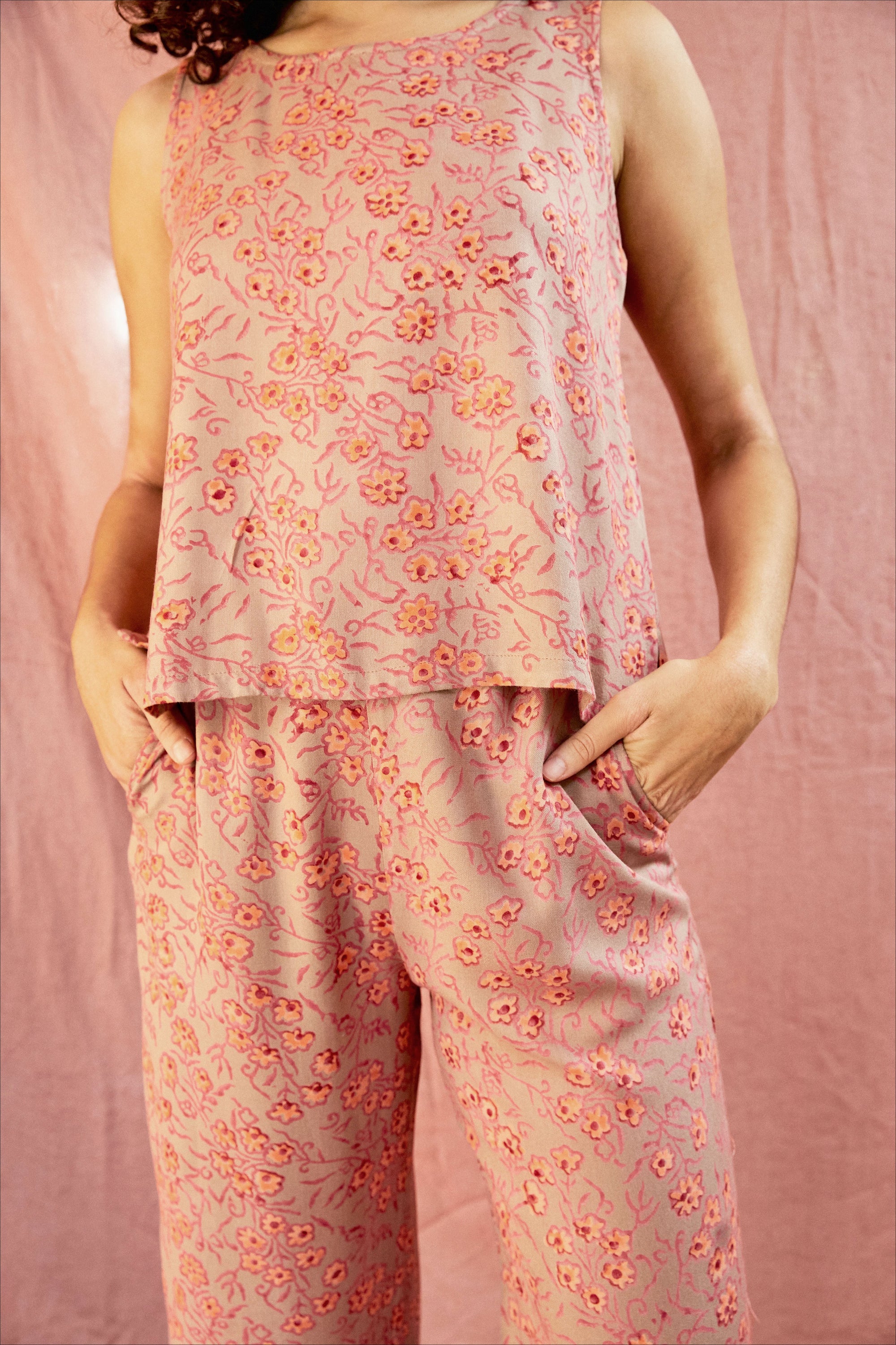 Model wearing the Birkin set, against a blush pink background, close up of pant pockets