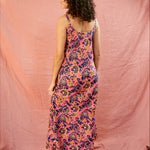 Model wearing the Kate strap dress against a blush background, showing the back of the dress