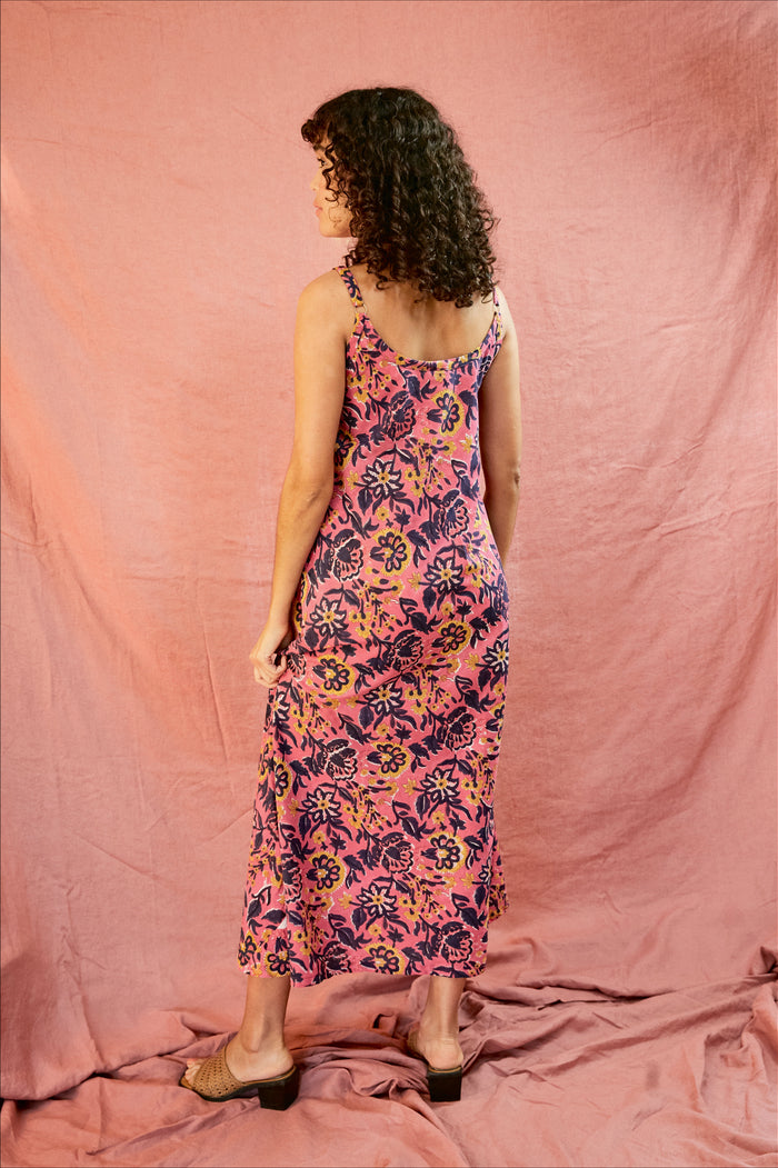 Model wearing the Kate strap dress against a blush background, showing the back of the dress