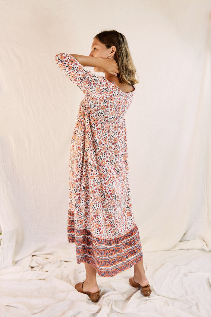 Model wearing the Mia dress against a cream backdrop