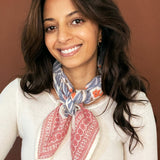 Model wearing the block printed Jane bandana tied around the neck against a brown background
