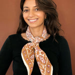 Model wearing the block printed Alexa bandana tied around the neck against a brown background