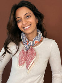 Model wearing the block printed Jane bandana tied around the neck against a brown background