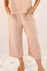 Model wearing Alba top and pant against a creamish background